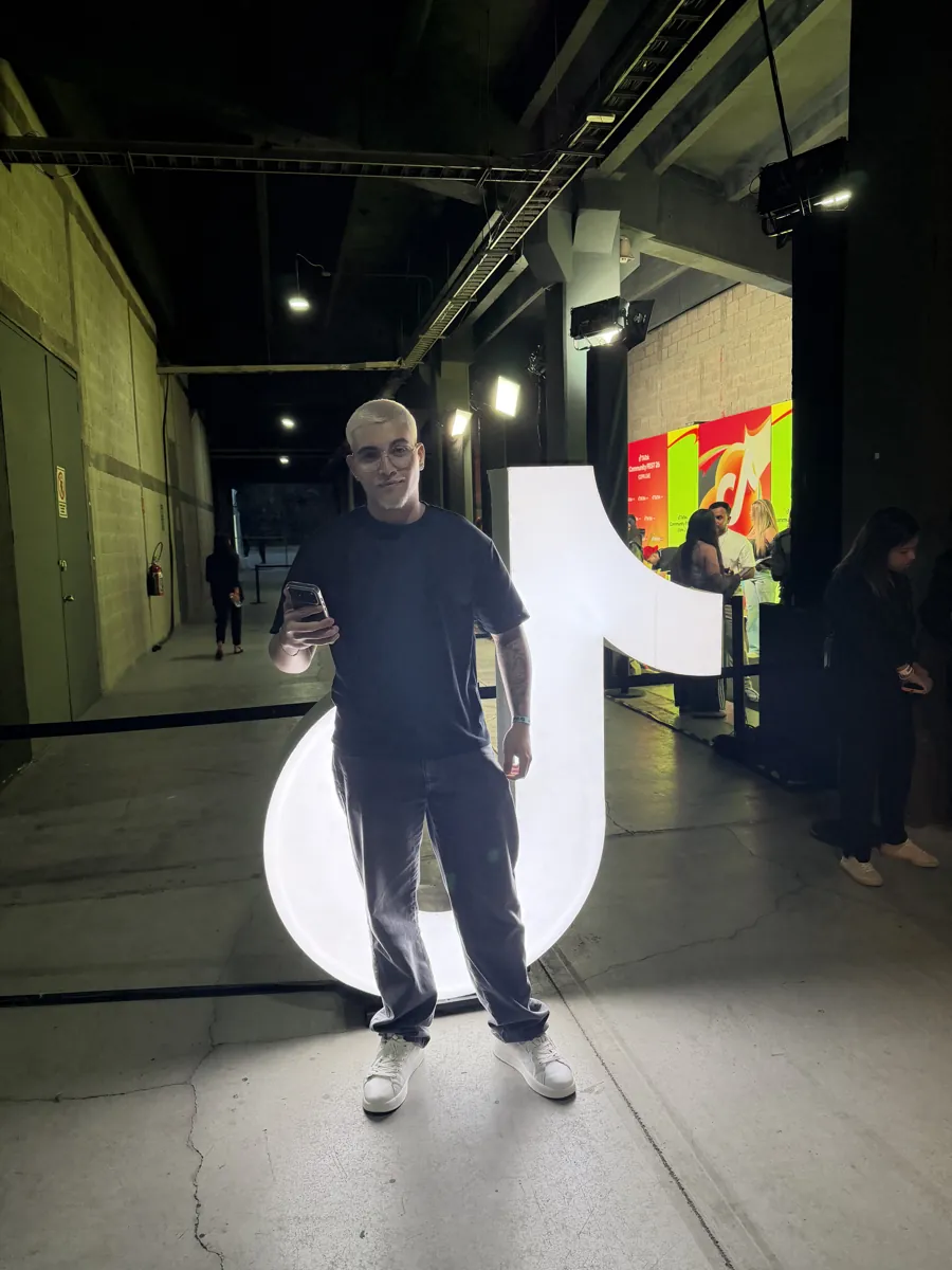 Streamer da Fusion ao lado do logo do TikTok num evento