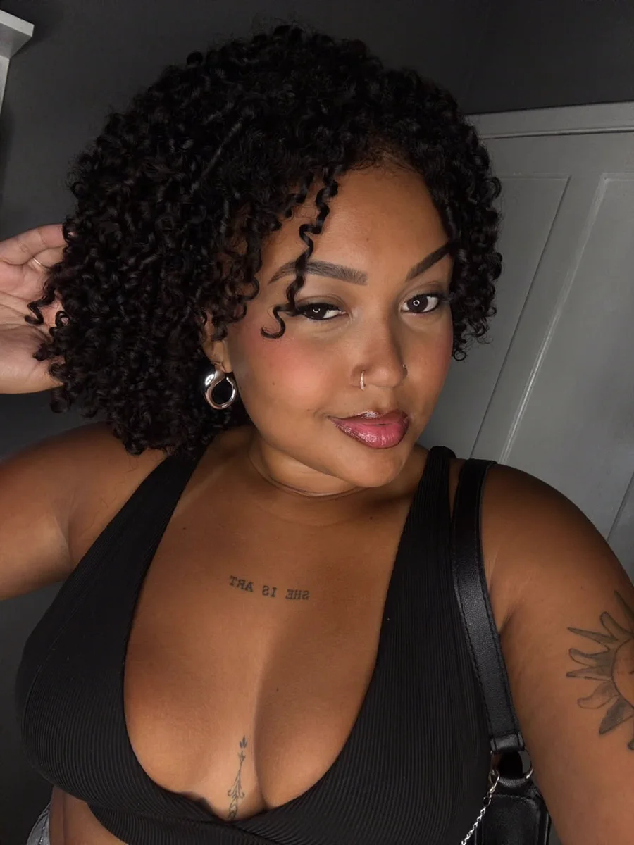 Kamilly, streamer da Fusion, de cabelo cacheado e top preto, em selfie
