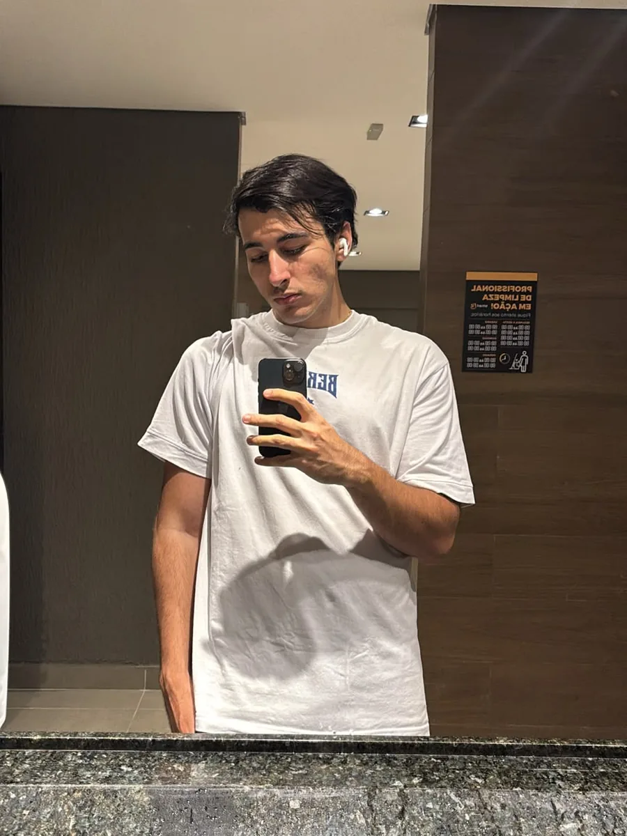 Lorenzo, streamer da Fusion, de camiseta branca, em selfie no espelho